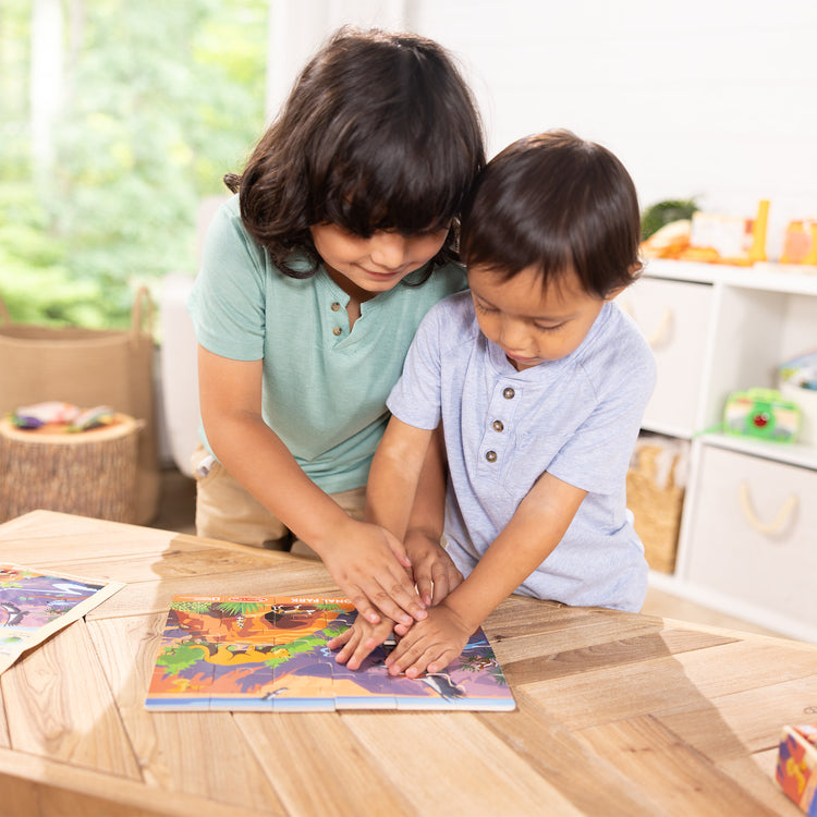 A kid playing with The Melissa & Doug Grand Canyon National Park Wooden Jigsaw Puzzle – 24 Pieces, Animal and Plant ID Guide