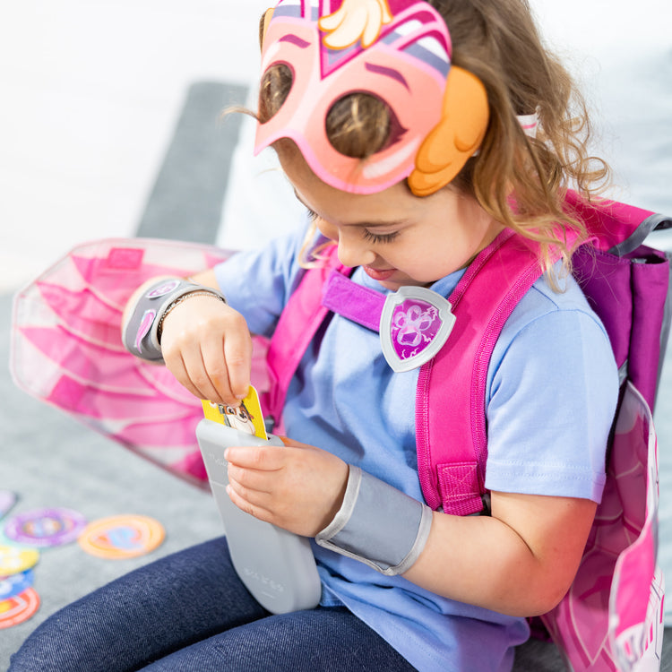 A kid playing with The Melissa & Doug PAW Patrol™ The Mighty Movie Mighty Skye Role Play Pack with Wings for Toddlers and Kids Age 3+