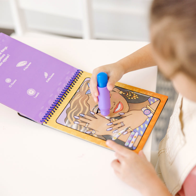 A kid playing with The Melissa & Doug On the Go Water Wow! Reusable Water-Reveal Activity Pad - Makeup and Manicures