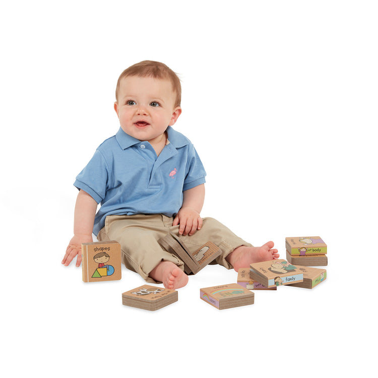 A child on white background with The Melissa & Doug Children's Book - Natural Play Book Tower: Little Learning Books