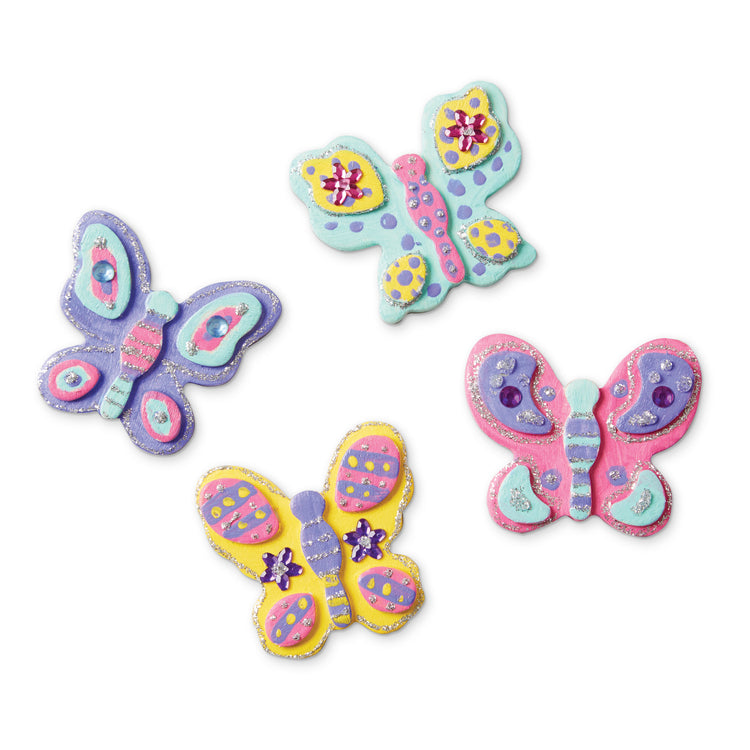 An assembled or decorated The Melissa & Doug Created by Me! Wooden Butterfly Magnets Craft Kit (4 Designs, 4 Paints, Stickers, Glitter Glue)