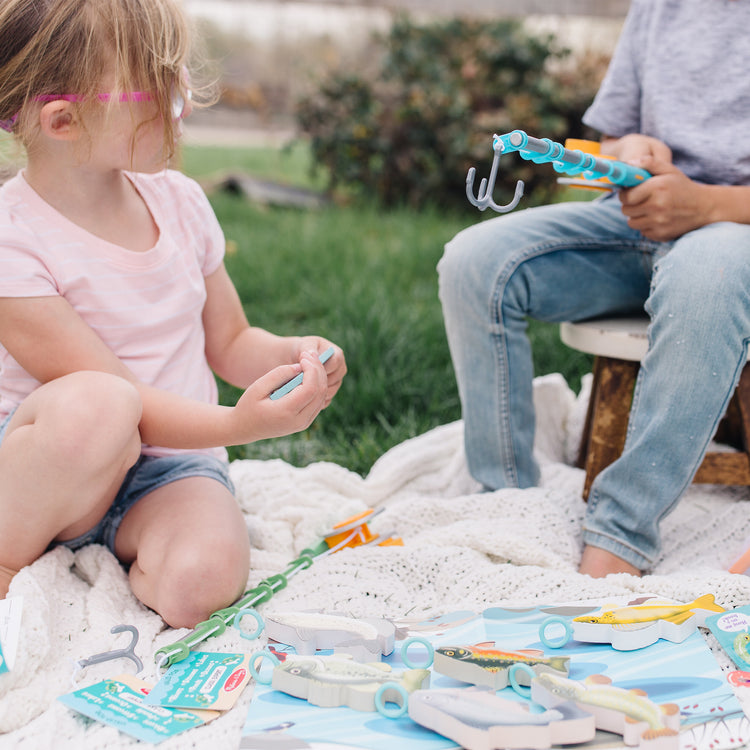 A kid playing with The Melissa & Doug Let’s Explore Fishing Play Set – 21 Pieces