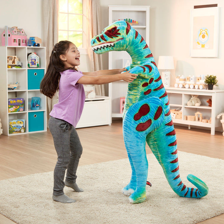 A kid playing with The Melissa & Doug Standing T-Rex Giant Lifelike Plush Stuffed Animal