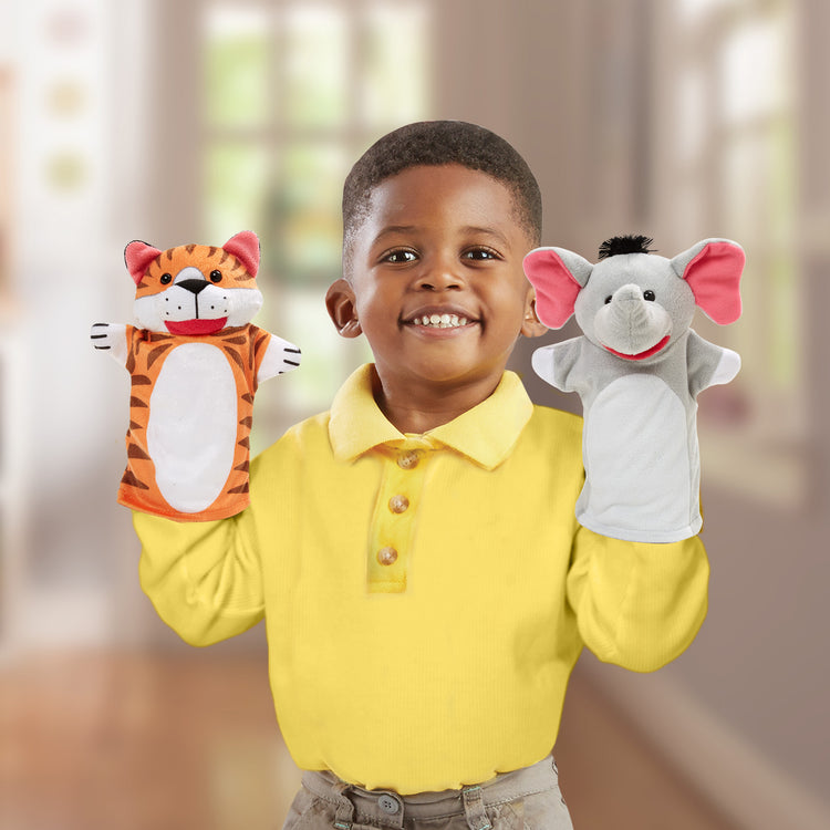 A kid playing with The Melissa & Doug Zoo Friends Hand Puppets (Set of 4) - Elephant, Giraffe, Tiger, and Monkey