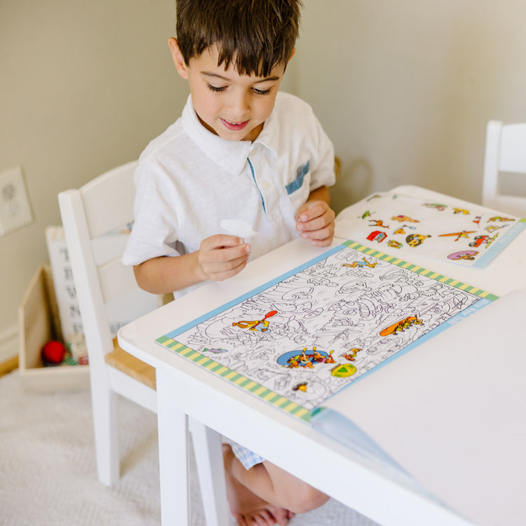 A kid playing with The Melissa & Doug Seek and Find Sticker Pad – Adventure (400+ Stickers, 14 Scenes to Color)