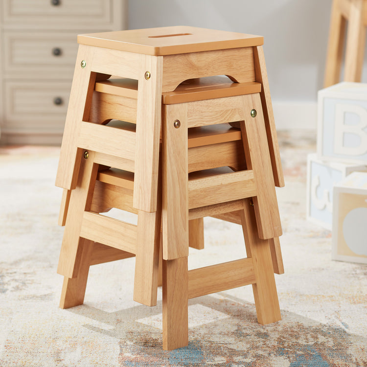 A playroom scene with The Melissa & Doug Wooden Stools – Set of 4 Stackable, Portable 11-Inch-Tall Stools (Natural)