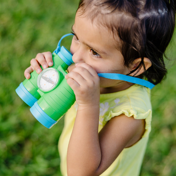 A kid playing with The Melissa & Doug Let's Explore Binoculars & Compass Play Set