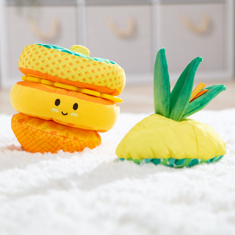 A playroom scene with The Melissa & Doug Multi-Sensory Pineapple Soft Stacker Infant Toy