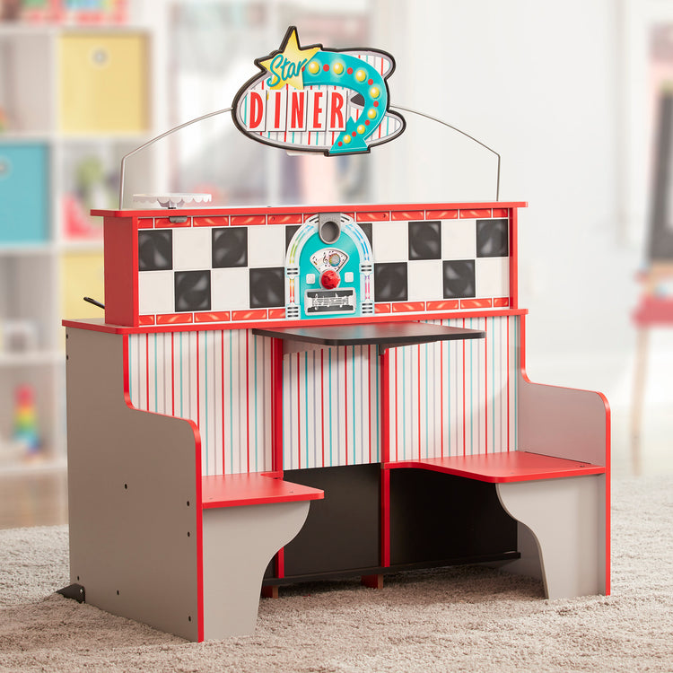 A playroom scene with The Melissa & Doug Double-Sided Wooden Star Diner Restaurant Play Space