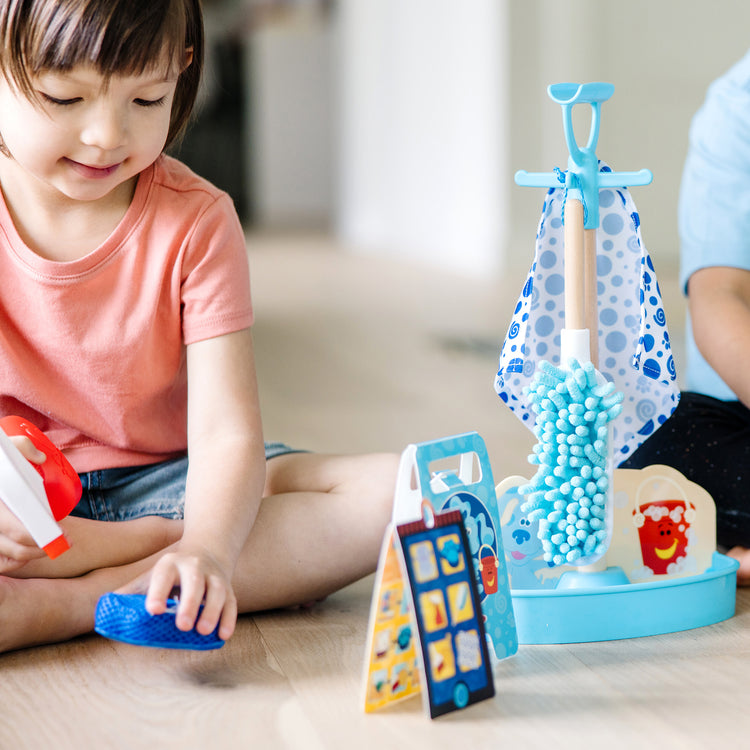 A kid playing with The Melissa & Doug Blue’s Clues & You! Clean-Up Time Play Set