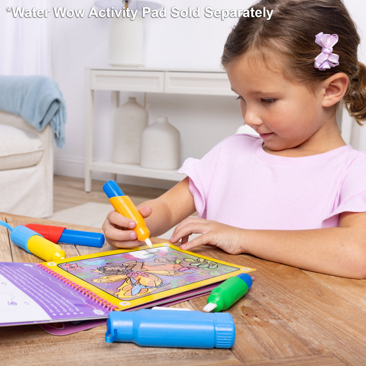 A kid playing with The Melissa & Doug Water WOW! Pen Pack - 4 Color-with-Water Pens, Sprayer, Tether Cap