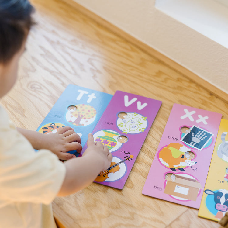 A kid playing with The Melissa & Doug Poke-a-Dot Alphabet Learning Cards