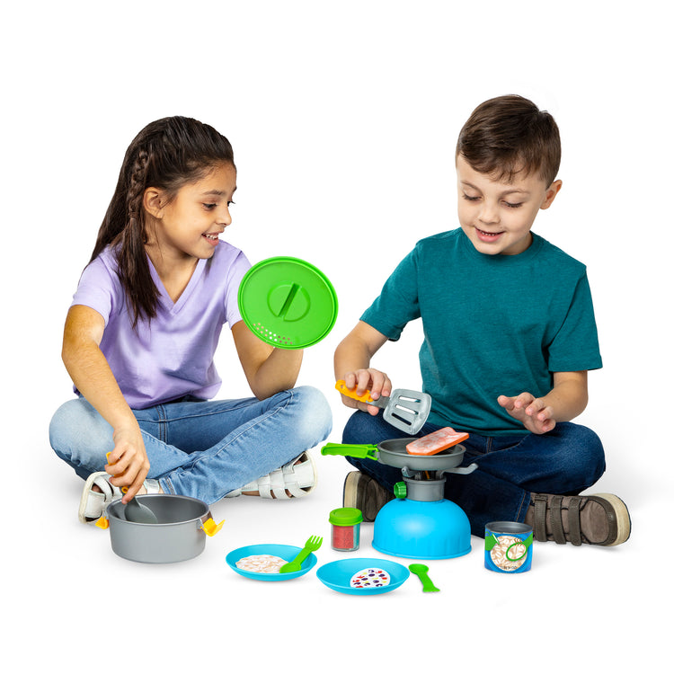 A child on white background with The Melissa & Doug Let’s Explore Outdoor Cooking Play Set – 27 Pieces