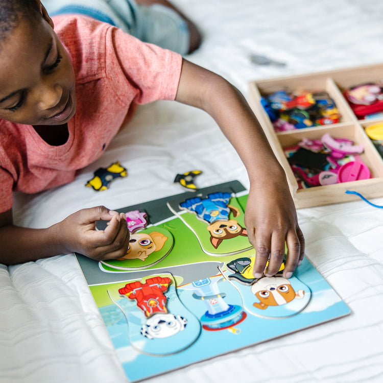 A kid playing with The Melissa & Doug PAW Patrol Wooden Magnetic Pretend Play (64 Pieces), Multi color