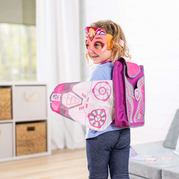 A kid playing with The Melissa & Doug PAW Patrol™ The Mighty Movie Mighty Skye Role Play Pack with Wings for Toddlers and Kids Age 3+