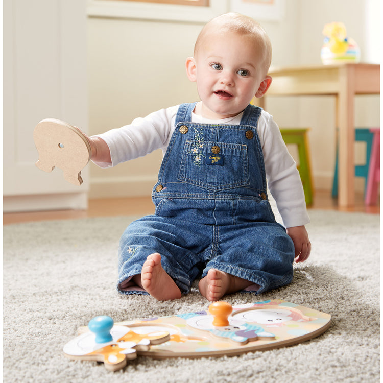 A kid playing with The Melissa & Doug First Play Wooden Jumbo Knob Farm Animal Puzzle (3 pcs)