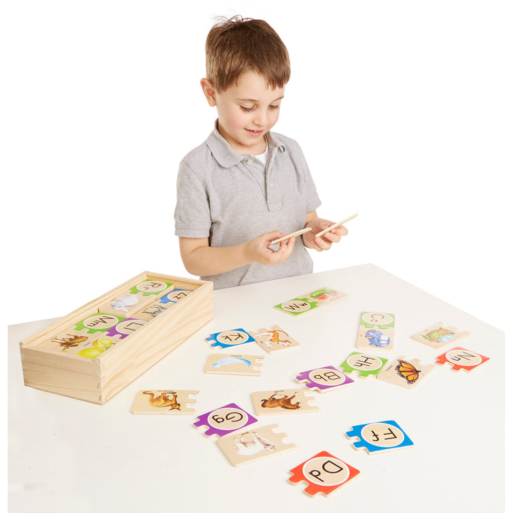 A child on white background with The Melissa & Doug Self-Correcting Alphabet Wooden Puzzles With Storage Box (52 pcs)