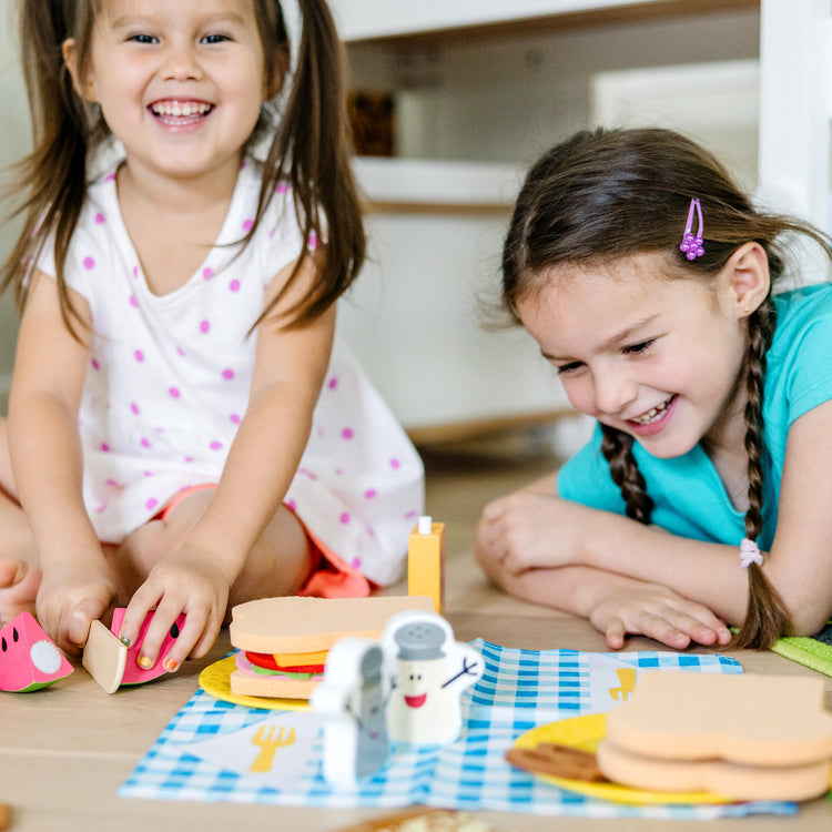 A kid playing with The Melissa & Doug Blue’s Clues & You! Share with Blue Picnic Play Set with Hand Puppet