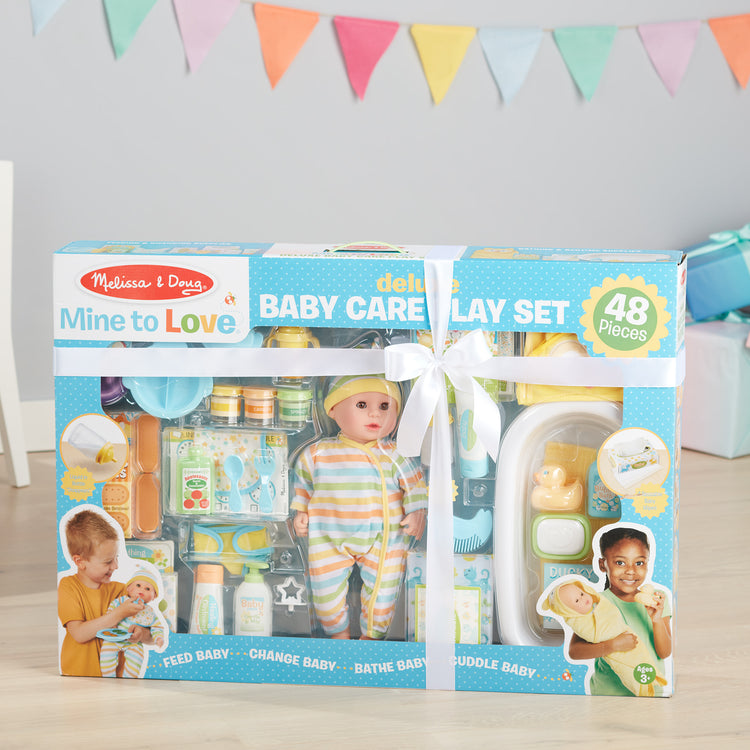 A playroom scene with The Melissa & Doug Mine to Love Deluxe Baby Care Play Set (48 Pieces – Doll + Accessories to Feed, Bathe, Change, and Cuddle)