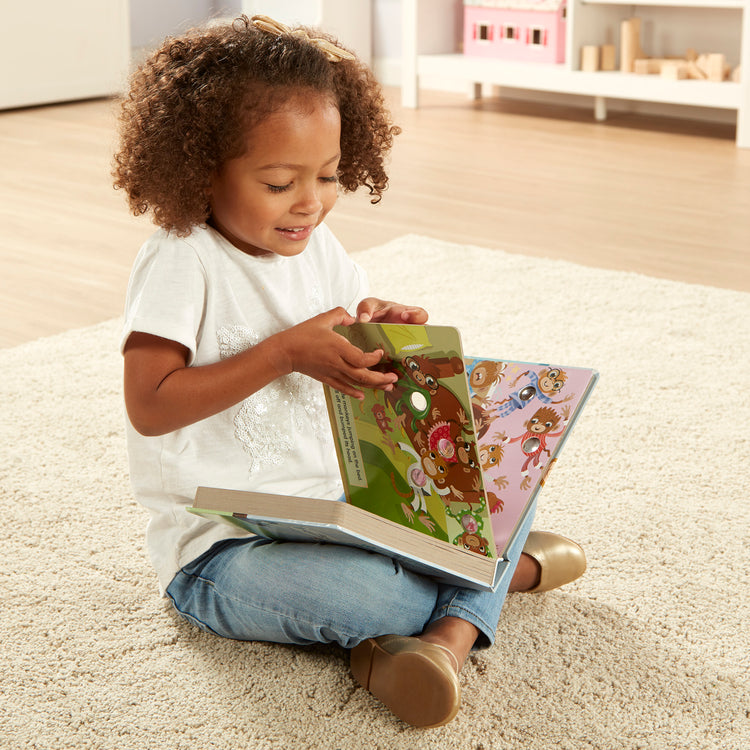 A kid playing with The Melissa & Doug Children's Book - Poke-a-Dot: 10 Little Monkeys (Board Book with Buttons to Pop)