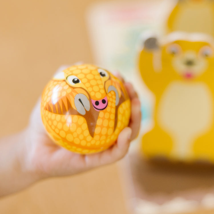 A kid playing with The Melissa & Doug Fun at the Fair! Wooden Armadillo Roll & Bowl Prairie Dog Bowling Game