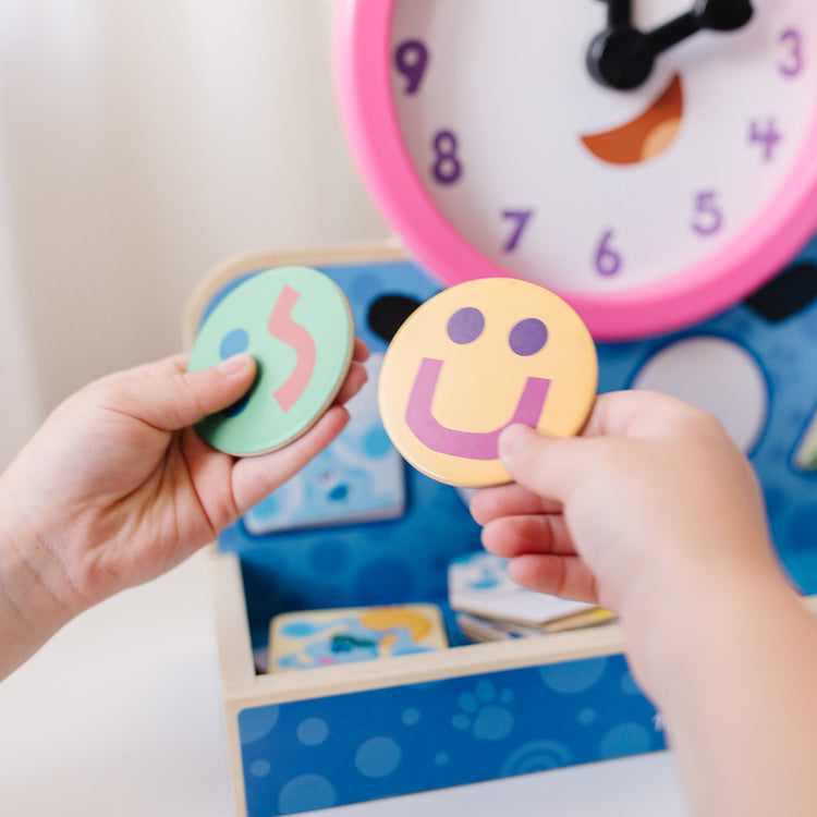 A kid playing with The Melissa & Doug Blue's Clues & You! Wooden Tickety Tock Magnetic Clock (31 Pieces)