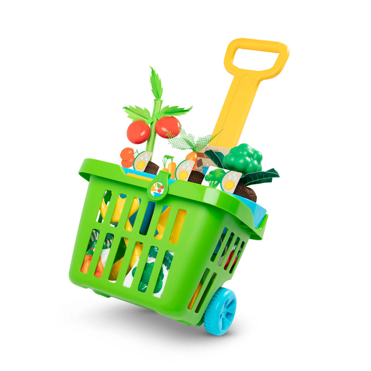 The loose pieces of The Melissa & Doug Let’s Explore Vegetable Gardening Play Set with Rolling Cart (31 Pieces)