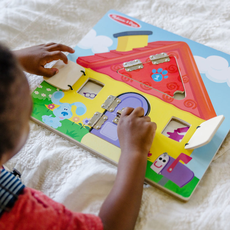 A kid playing with The Melissa & Doug Blue’s Clues & You! Wooden Activity Board with Clue Cards