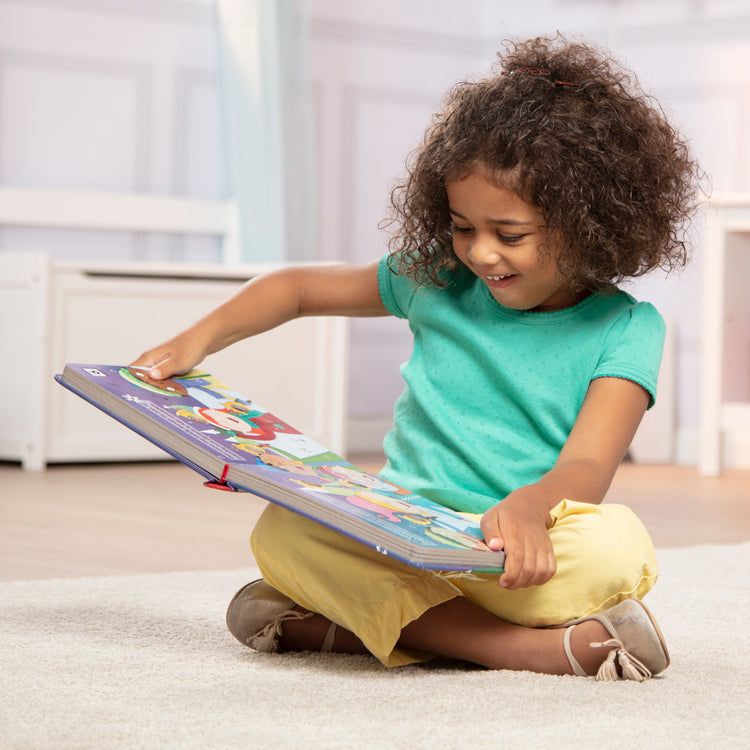 A kid playing with The Melissa & Doug Children's Book - Poke-a-Dot:The Night Before Christmas (Board Book with Buttons to Pop)