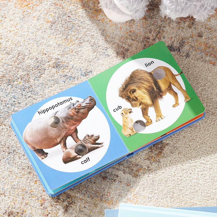 A playroom scene with The Melissa & Doug Children’s Book – Poke-a-Dot: Wild Animal Families (Board Book with Buttons to Pop)