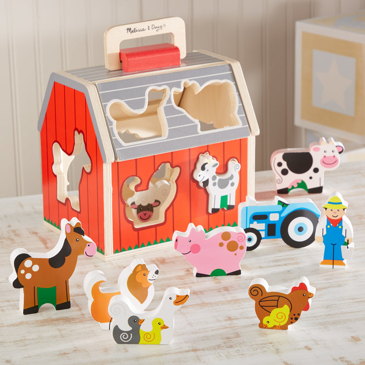 A playroom scene with The Melissa & Doug Wooden Take-Along Sorting Barn Toy with Flip-Up Roof and Handle 10 Wooden Farm Play Pieces