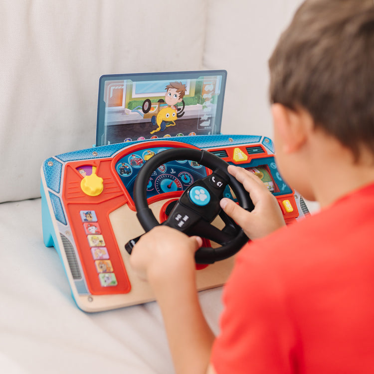 A kid playing with The Melissa & Doug PAW Patrol Rescue Mission Wooden Dashboard