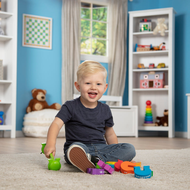 A kid playing with The Melissa & Doug Counting Caterpillar - Classic Wooden Toy With 10 Colorful Numbered Segments