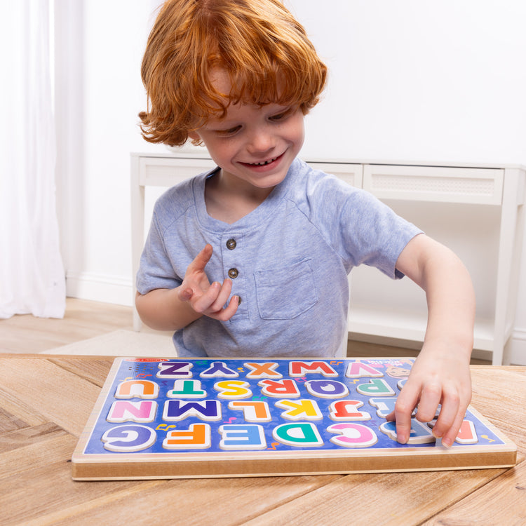 A kid playing with The Melissa & Doug® Ms. Rachel™ Wooden Phonics Alphabet Sound Puzzle, 24-Piece Toddler Toys for Boys and Girls Ages 2+ Years