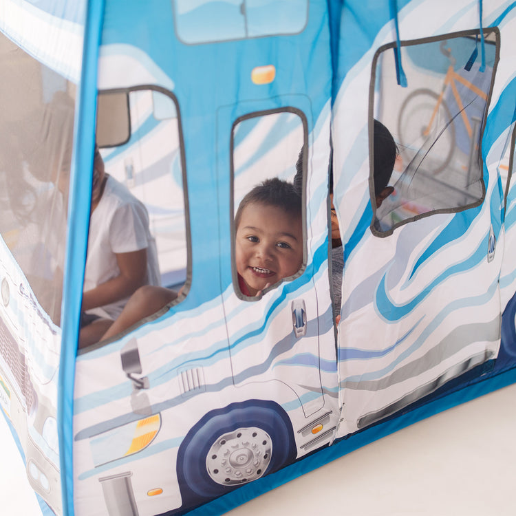 A kid playing with The Melissa & Doug Let’s Explore Camper Tent Play Set – 47” x 31” x 39” Assembled