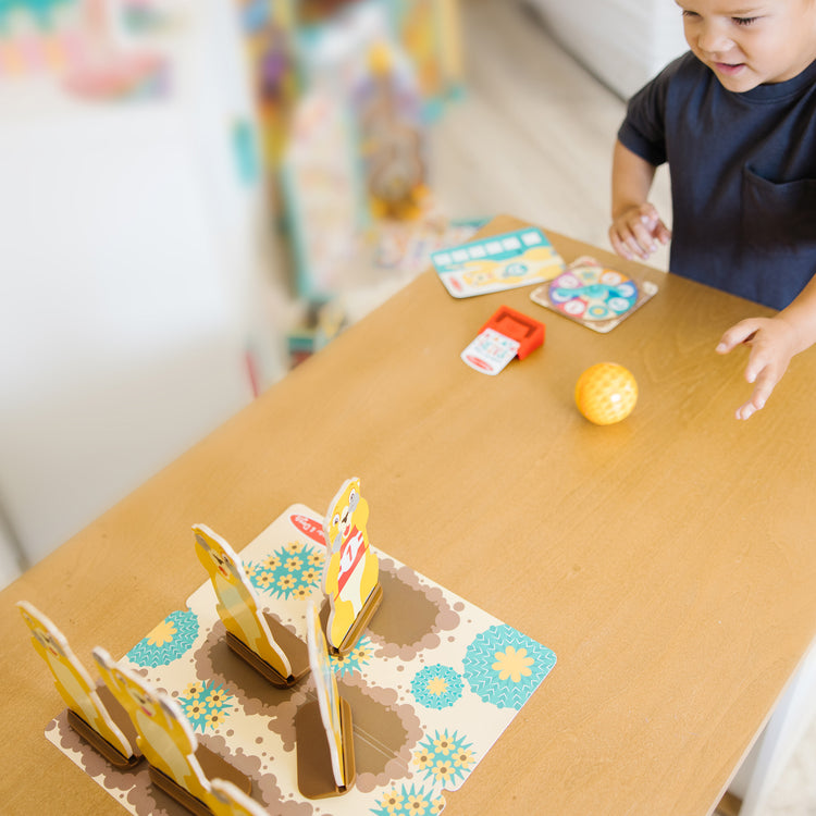 A kid playing with The Melissa & Doug Fun at the Fair! Wooden Armadillo Roll & Bowl Prairie Dog Bowling Game