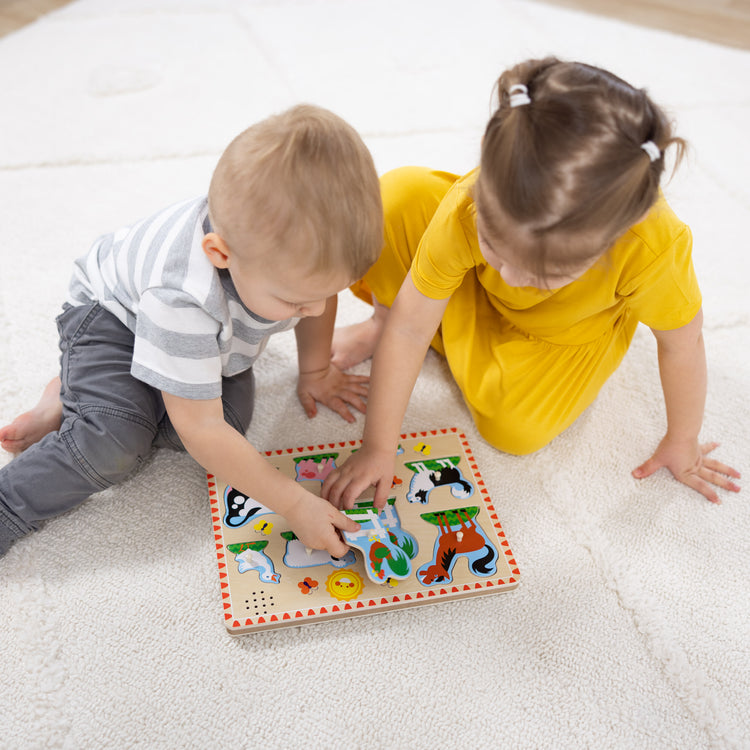 A kid playing with The Melissa & Doug Wooden Sound Puzzle 2-Pack for Toddler and Preschool Boys and Girls – Farm Animals, Vehicles