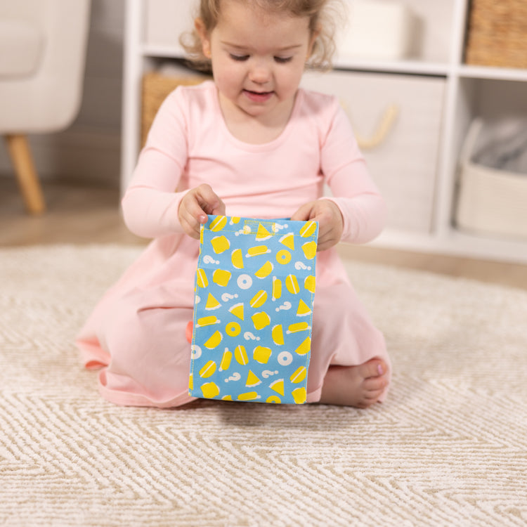 A kid playing with The Melissa & Doug What’s for Lunch?™ Surprise Meal Play Food Set Series 2