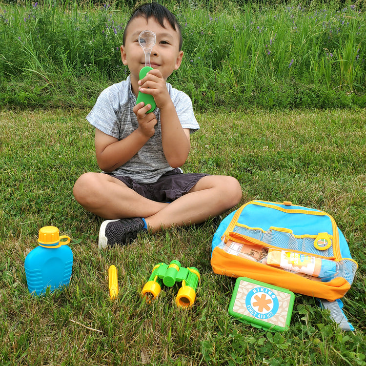 A kid playing with The Melissa & Doug Let’s Explore Hiking Play Set – 23 Pieces