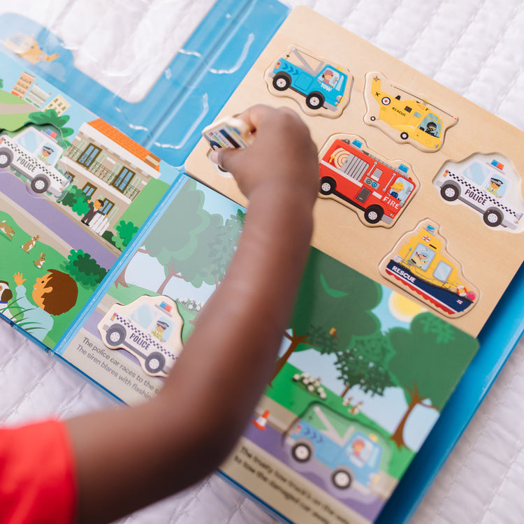 A kid playing with The Melissa & Doug To the Rescue Book and Wooden 6-Piece Puzzle Play Set