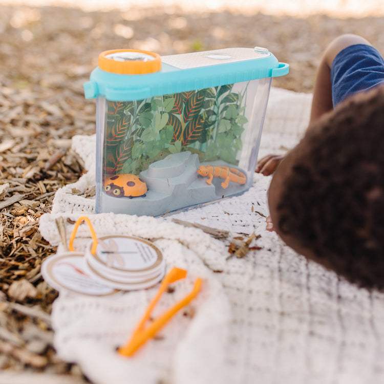 A kid playing with The Melissa & Doug Let’s Explore Terrarium Observations Play Set (16 Pieces)