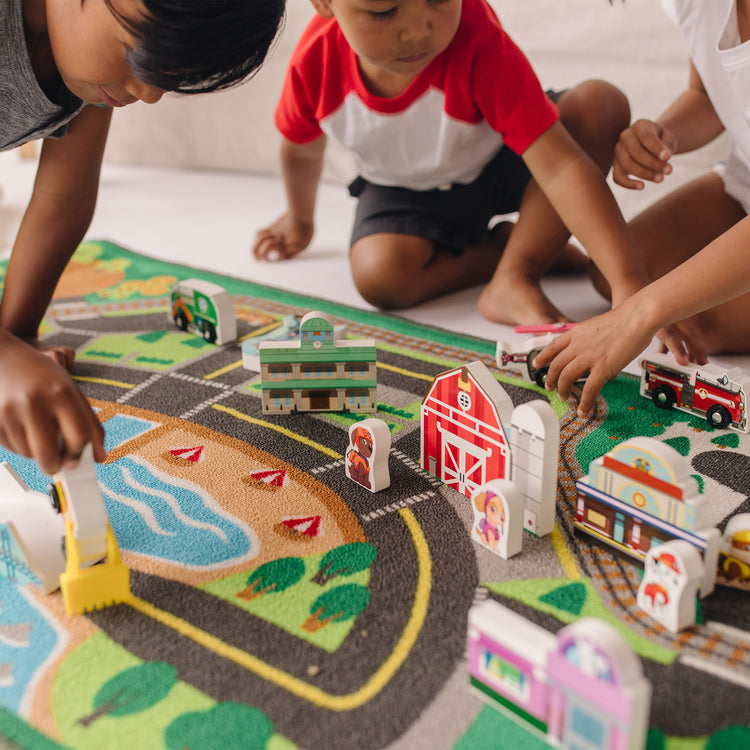 A kid playing with The Melissa & Doug PAW Patrol Activity Rug - Adventure Bay (22 Pieces)