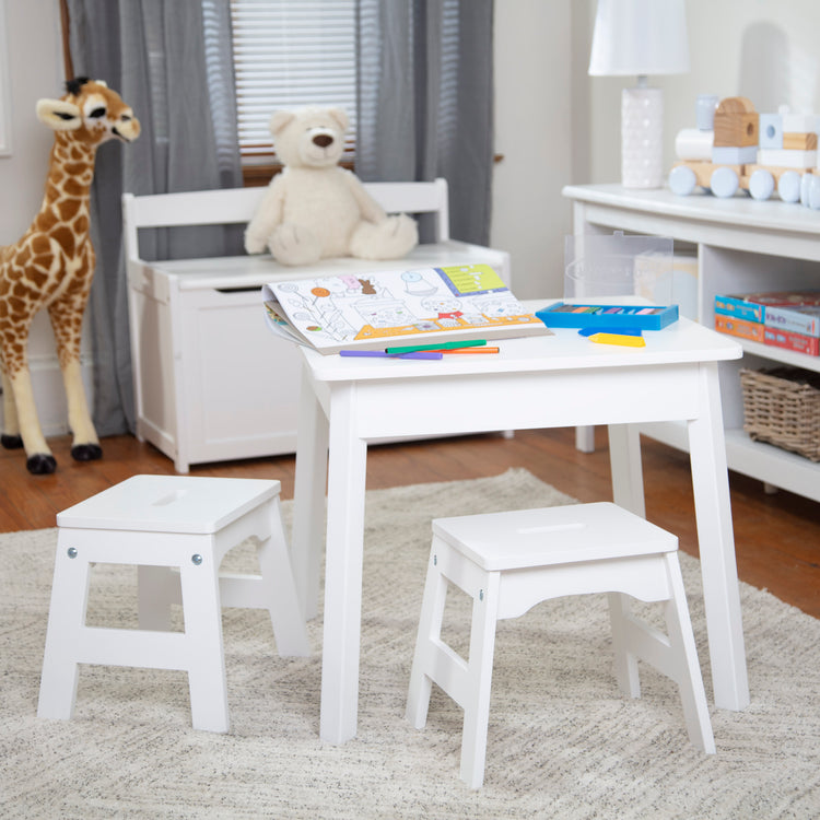 A playroom scene with The Melissa & Doug Wooden Stools – Set of 2 Stackable, Portable 11-Inch-Tall Stools (White)