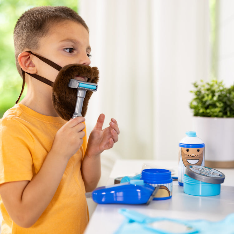 A kid playing with The Melissa & Doug Barber Shop Pretend Play Set Shaving Toy for Boys and Girls Ages 3+