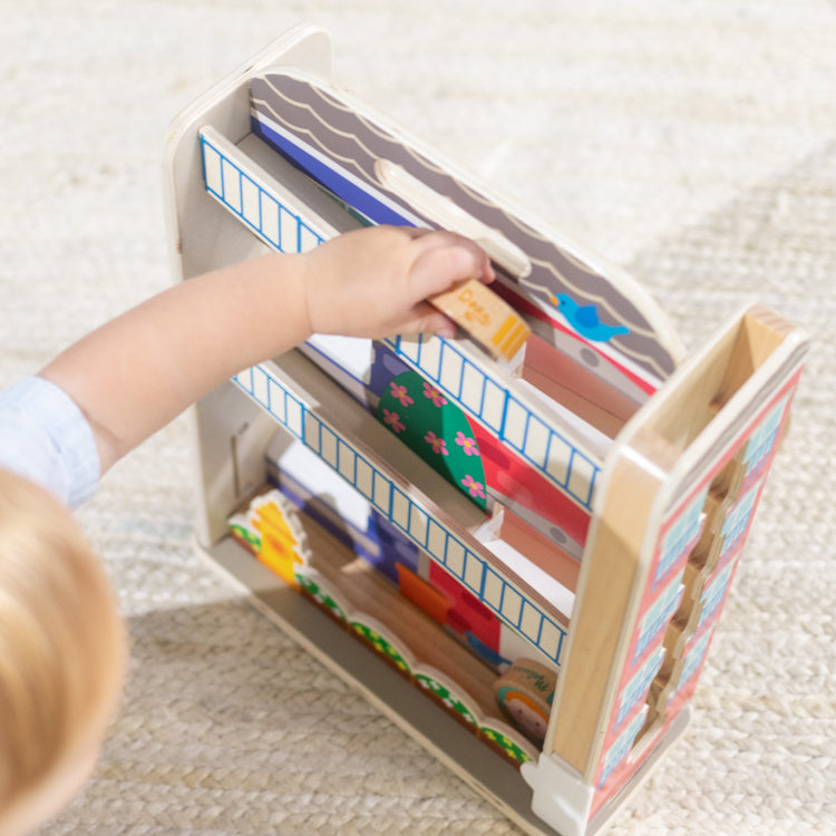 A kid playing with The Melissa & Doug GO Tots Wooden Town House Tumble with 6 Disks