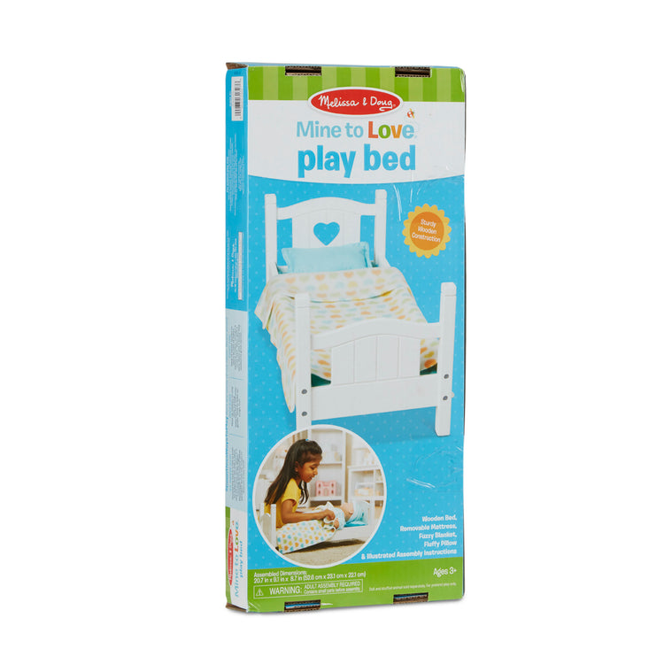 The front of the box for The Melissa & Doug Mine to Love Wooden Play Bed for Dolls, Stuffed Animals - White (8.7”H x 9.1”W x 20.7”L Assembled)