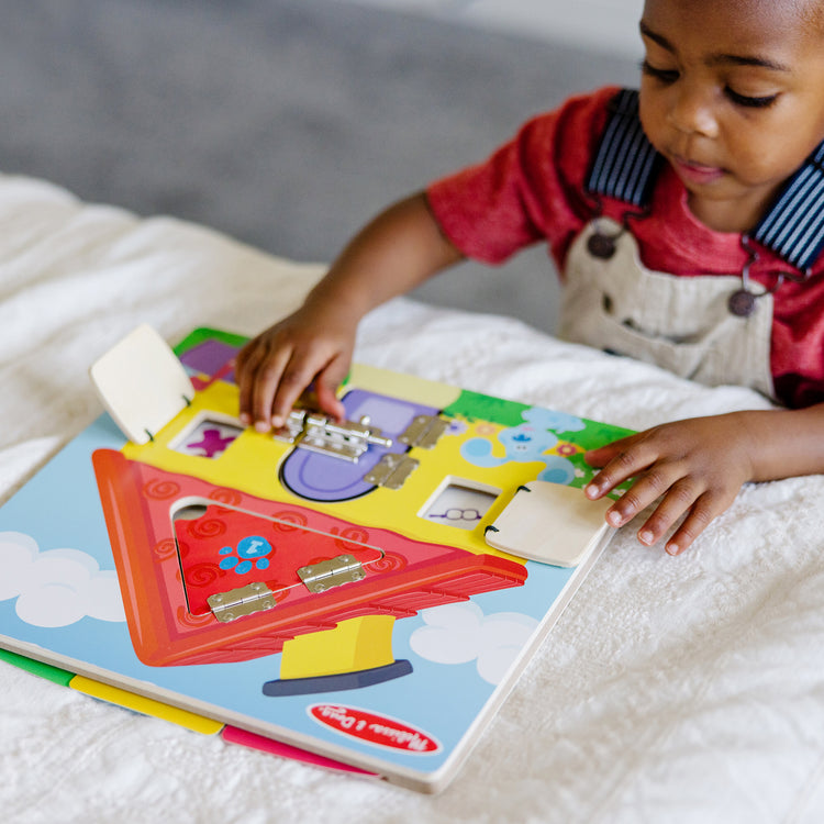 A kid playing with The Melissa & Doug Blue’s Clues & You! Wooden Activity Board with Clue Cards