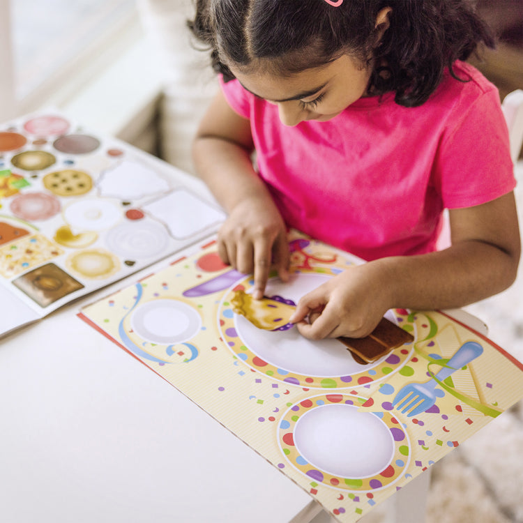 A kid playing with The Melissa & Doug Sticker Pads 3-Pack - Sweets and Treats, Make-a-Face Fashion, and Make-a-Meal