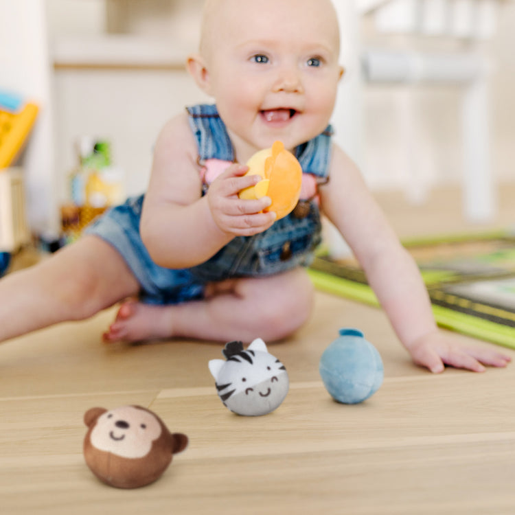 A kid playing with The Melissa & Doug Rollables Safari Friends Infant and Toddler Toy (4 Pieces)