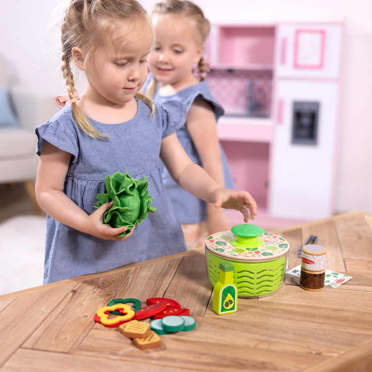 A kid playing with The Melissa & Doug Salad Spinner Play Set, Pretend Play Food for Boys and Girls Ages 3+